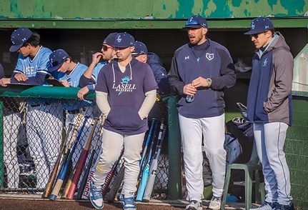 (L-R) Associate head coach Gary Trottier, head coach Billy Uberti, and assistant coach Matt Sammarco standing outside their dugout during their opener against Fisher College. Trottier will lead the new leader of the JV. 