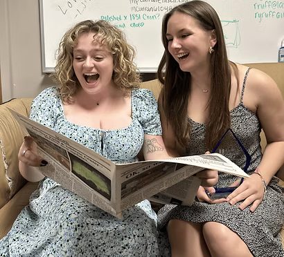 Senior Arts Editor Caitlin Orsino (left) and senior Editor-in-Chief Hanna Babek read the first edition of the Chronicle published during their time on campus.