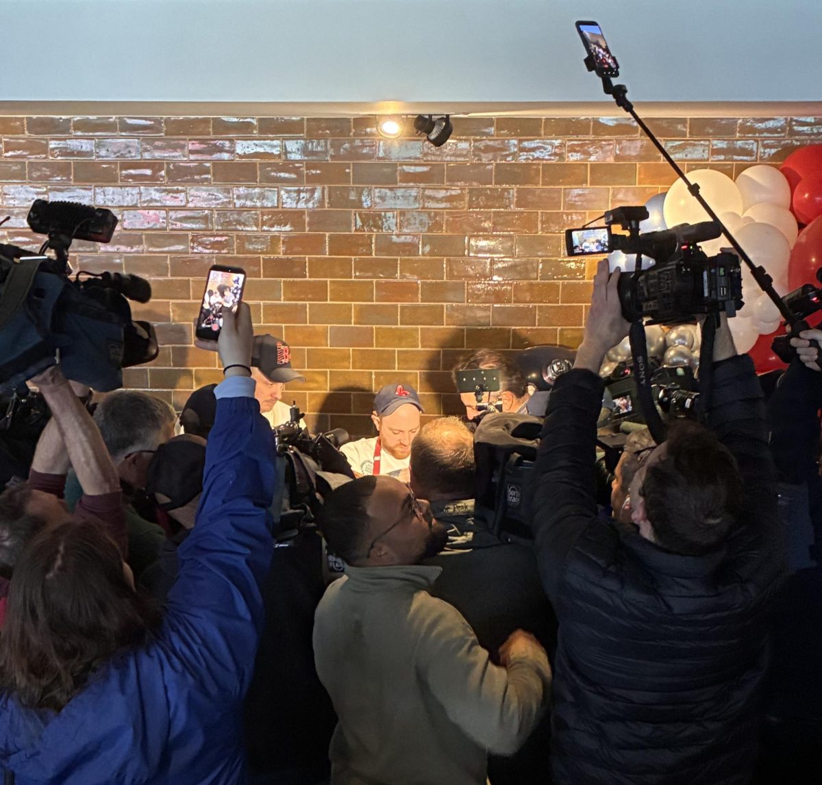 Hungry journalists crowd around the tastings table during Media Day at Fenway Park on April 2, 2026.