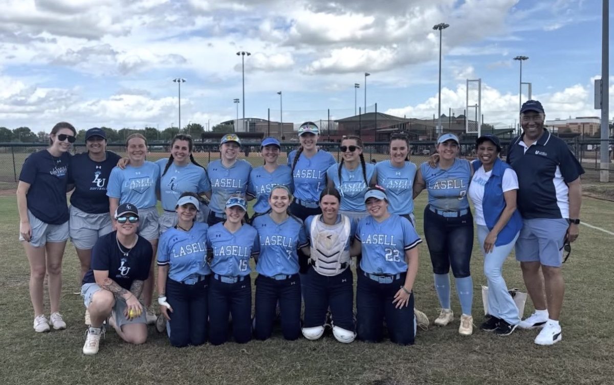 The softball team in Clermont, FLA poses postgame with Lasell President Eric Turner and Presidential Spouse Wanda Whitmore. (Photo courtesy of Abby Fortin)